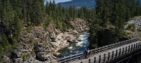 Biking on a trestle bridge on the Kettle Valley Trail in Christina Lake | Hubert Kang