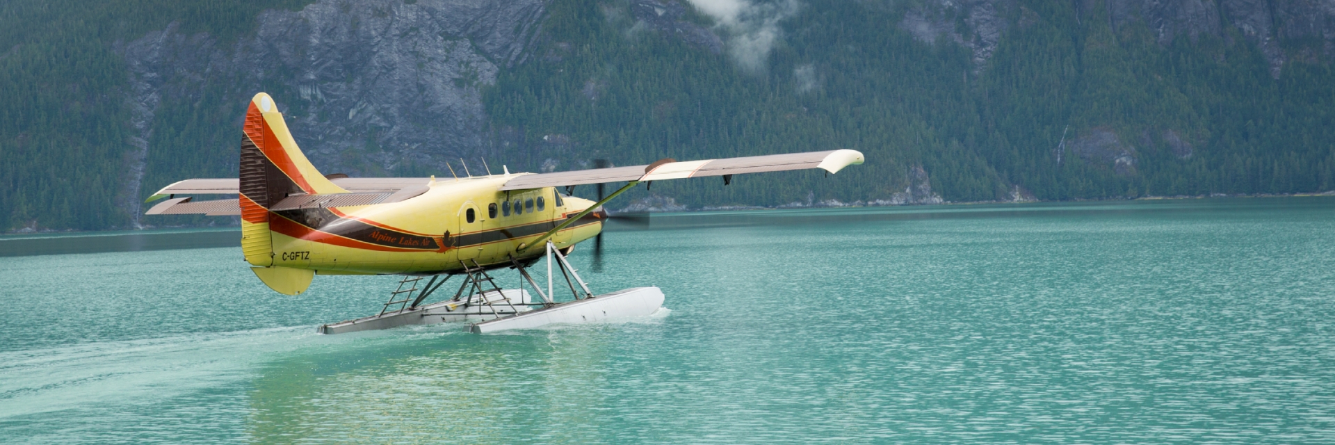 A float plane landed on the water near a mountain range