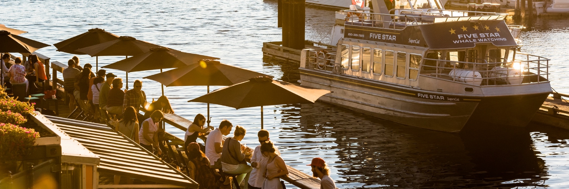 People enjoying food on the patio overlooking the marina in Victoria's Inner Harbour